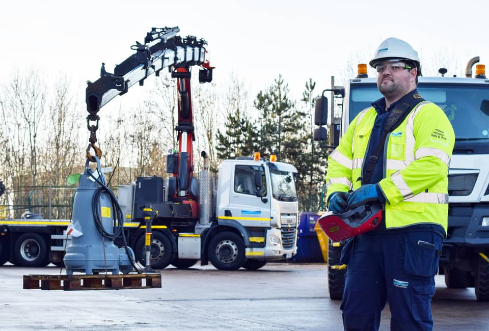 Yorkshire Water employee stands in front of a truck with heavy lifting equipment