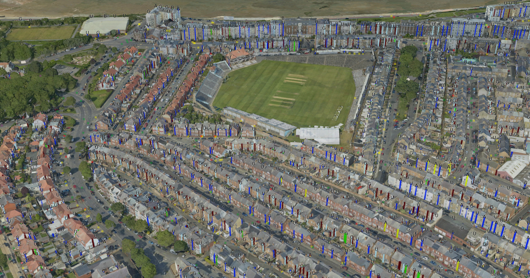 Aerial shot of a town with coloured markings on sides of buildings