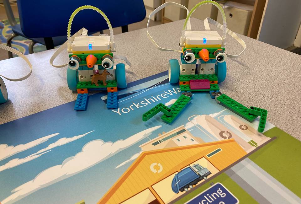 Two LEGO robots sitting on a map with a Yorkshire Water logo