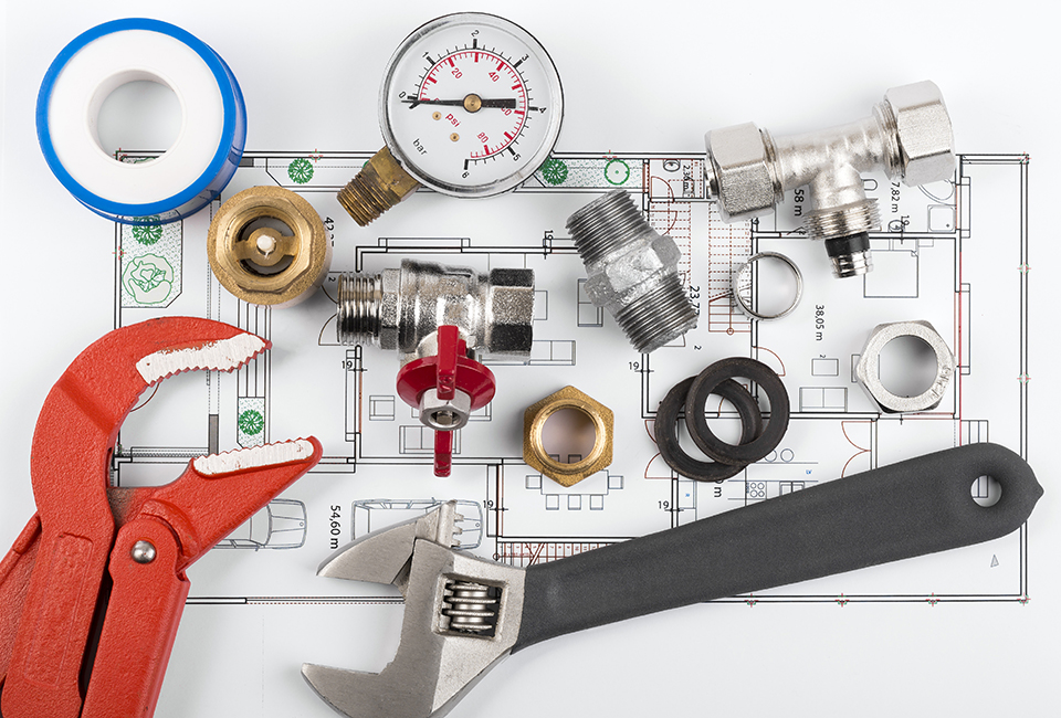 Plumbing tools and equipment on blueprint