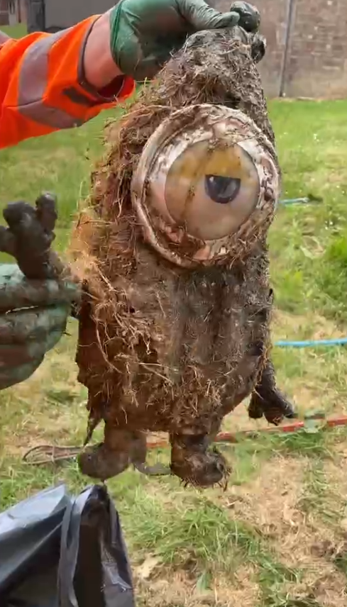 dirty minion toy held up by person in Personal protective equipment