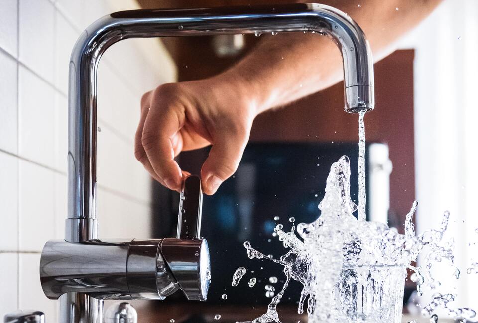 Water splashing out of glass in kitchen sink