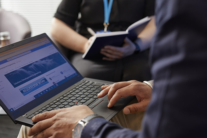 Colleagues gathered around a laptop