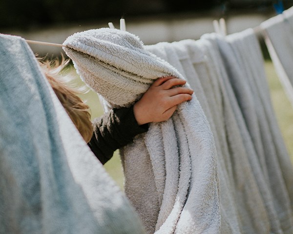 Little boy peeking through washing on the line