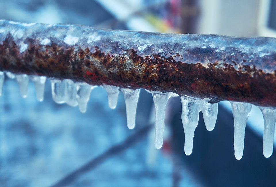 Frozen pipe with icicles coming down from it
